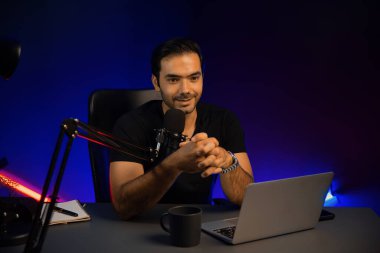 Yayıncı, fanclub dinleyicisiyle mikrofon kullanarak konuşuyor. Mor neon ışıklı modern stüdyoda yaratıcı olumlu düşünce konseptiyle canlı yayında finansal sorunları tartışıyor. Tahmin et..