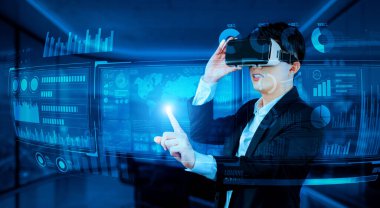 VR gözlüklü bir proje yöneticisi mali tabloyu ve ofisteki parlak mavi ışığı gösteriyor. Yetenekli iş adamı artırılmış gerçeklikten elde edilen verileri kullanarak pazarlama stratejisini kontrol edip planlıyor. Yaratıcılık.