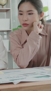 Ofis çalışma alanında birlikte çalışan iki genç hevesli iş kadını. Genç meslektaşlar tartışırken ve dizüstü bilgisayar kullanırken. Modern ofis çalışanları masada birlikte oturuyorlar..