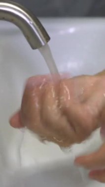 Coronavirus hastalığının önlenmesi için ellerini yıka. 2019 veya COVID-19. İnsanlar virüs enfeksiyonunu temizlemek için lavaboda ellerini yıkıyor..