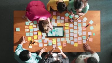 Ux Ui tasarımı kullanılarak dijital program ve yazıları tartışan ve gösteren geliştirici ekibin hava görüntüsü. İş dünyasına tepeden bakan insanlar telefon ve bilgisayar için kablo prototipi geliştiriyorlar. Sempozyum.