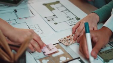 İşbirlikçi bir çalışma alanı planı üzerinde mimari planlar çizen elleri gösteriyor. Bu ortam yaratıcılığı ve profesyonel stratejiyi teşvik ediyor. SACTR