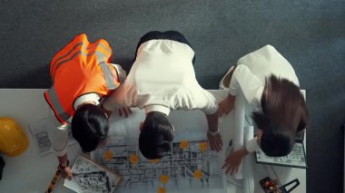 Proje yöneticisi ve inşaat mühendisinin dizüstü bilgisayarlarını incelerken bu fikri mimara da açıkla. Akıllı iş adamlarının bina inşaatı hakkında konuştuğu ve beyin fırtınası yaptığı hava görüntüsü. Hizalama.