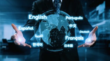 Bir iş adamı, küresel iletişim ve işbirliğinin önemini sembolize eden çağdaş bir ofiste çeşitli dillerle çevrili parlak bir küre sunar. Dörtgen