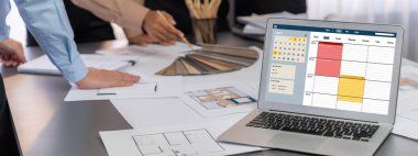 İç mimar tasarımcı grubu, daha kesin tasarım için planlar ve dizüstü bilgisayar ekran mimari yazılımı üzerinde birlikte tartışıyorlar. Modern ev tasarımı ve yenileme. İçgörü