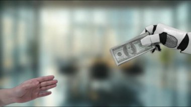 Bir robot el, teknoloji ve finansmanın modern bir iş ortamında birleşmesini temsil eden bir insan eliyle dolarları takas eder. MZL