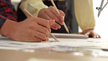 Mimarlar veya akıllı mühendislerin videosu mimari ofisindeki inşaat doğruluğu için taslak üzerinde ölçüm aracı, bölücü ve kalem el yazısı detaylarını kullanır. Eline odaklan. - Yakın çekim. Tanımlama.