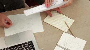 Akıllı mimar ve akıllı mühendisin dizüstü bilgisayarlı videosu mimarlık bürosundaki inşaat isabet planı hakkında tartışıyorlar. Eline odaklan. - Yakın çekim. Tanımlama.