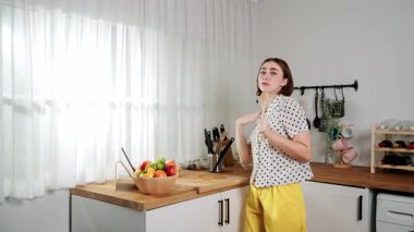 Enerjik beyaz anne kahvaltı için salata pişirirken ve yemek pişirirken elinde kepçeyle şarkı söylüyor. Sağlıklı yemek yapmaya hazırlanırken müziğe yönelen mutlu ev sahibi. Pedagoji.