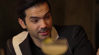 Takım elbiseli akıllı bir adam, grup veya çift olarak lüks bir barda gece hayatı yaşayan bulanık limonlu Margarita kokteyli kabuğuyla canlı sohbete girişiyor. Vinosity.