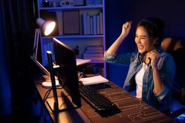 Sunucu kanalı Asyalı etkileyicisi canlı yayında konuşuyor. Sosyal medyada kulaklık takıyor, bilgisayar kaydı yapıyor, dinleyicileri selamlıyor ve Neon Modern Stüdyoları 'nda online olarak koçluk yapıyor. Taktik.