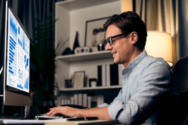 Akıllı iş adamı iş paragrafı dinamik pazarlama analizi planını analiz ediyor. Kağıt kağıtları ve bilgisayar monitörü raporlarını gece evdeki belge verileriyle karşılaştırmak için hazırlıyor. Bireysel.