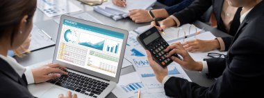 İş zekası ve veri analizi kavramı. Analizci ekibi laptop ekranında finansal veri analizi üzerinde çalışıyor. Etkili iş stratejik planlama için pazarlama göstergesi olarak. İçgörü