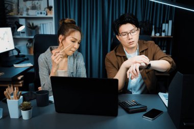 Satış müdürleri e-posta göndermeyi beklerken, gece geç saatlerde modern ofiste mesai saatlerinde rapor veri analizi için fazla mesai ile birlikte çalışıyorlar. İnfobahn.