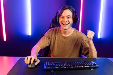 Kazanmak için çevrimiçi oyun oynayan akıllı flama makinesinin sunucu kanalı, neon ışıklı odada seçilen takım yarışması için izleyicilerle birlikte canlı yayında canlı yayında kulaklık takıyor. Bireysel.