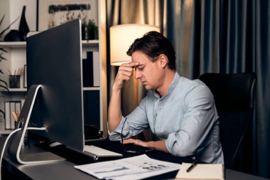 Dinamik veritabanı pazarlama analizi ile PC ekranındaki iş paragrafını araştıran stresli finansal analistin gece vakti modern ev ofisinde aylık rapor hazırlamasını düşünüyorum. Bireysel.