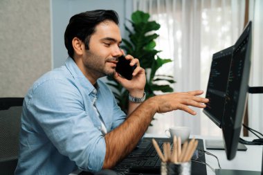 Akıllı IT geliştirici yöneticisi, bilgisayar ekranındaki yazılım kodlama sistemindeki sorunu çözen iş arkadaşına seslenerek modern ofiste uygulama programı güncellemesi yapıyor. Tahmin et..
