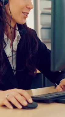 Ofiste çalışan kulaklık takan işadamları uzak müşteri ya da meslektaşlarını desteklemek için çalışıyorlar. Arama merkezi, tele pazarlama, müşteri destek acentesi telefon görüşmesinde hizmet sunar.