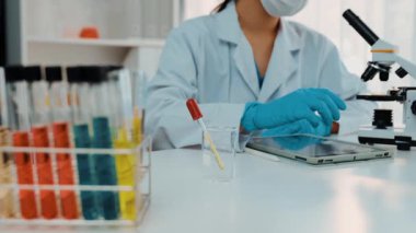 Laboratuvar kimya araştırmacısı mikroskop kullanarak yeni ilaç ya da tedavi geliştirir. Laboratuvar mikrobiyoloji ekipmanları ile bilimsel uzmanlık ile sağlık hizmetlerinin teknolojik gelişimi. Ağır çekim. Katı.