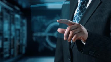 Takım elbiseli profesyonel bir işadamı dijital ekranla etkileşime geçerek çeşitli programlama dilleri ve kodları sergiliyor. Bu görüntü, iş yerindeki teknoloji ve modern gelişimi temsil ediyor. Dörtgen