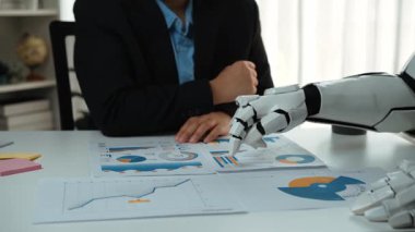 Profesyoneller, yüksek teknolojili bir şirket ortamında, stratejik bir brifingde yapay zekanın oluşturduğu, araştırma güdümlü pazarlama planlarını entegre ederler. Noogenesis Yapay Zeka