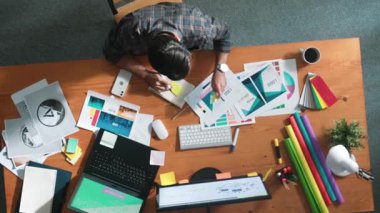 Rengi seçerken akıllı iş adamının müdürü aramasının havadan görüntüsü. Toplantıda ürün için ana tema rengini seçerken ve tasarlarken dizüstü bilgisayara bakan profesyonel iç mimar. Sempozyum.