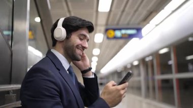 Tren istasyonunda geçmişi bulanık bir şekilde beklerken kulaklıkla müzik dinleyen zeki bir iş adamı. Yetenekli proje yöneticisi cep telefonu tutarken dinlenme sesi dinlemeyi sever. Sevinçli..