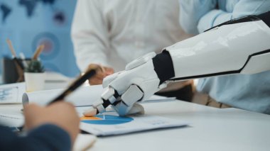 Robotik bir kol modern bir ofiste iş dünyasından profesyonellerle birlikte veri analizi yapar ve teknoloji ile insan zekası arasındaki işbirliğini gözler önüne serer.