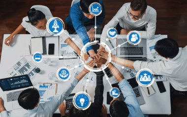 Üst düzey ofis çalışanları ofis odasında el ele tutuşarak iş sinerjisini ve iş yerindeki güçlü üretken takım çalışmasını sembolize ediyor. İş çalışanları arasındaki işbirliği ve birlik. İhtiyatlı Dostluk