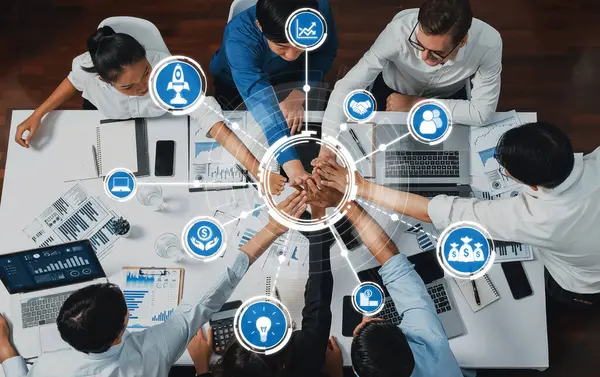 Üst düzey ofis çalışanları ofis odasında el ele tutuşarak iş sinerjisini ve iş yerindeki güçlü üretken takım çalışmasını sembolize ediyor. İş çalışanları arasındaki işbirliği ve birlik. İhtiyatlı Dostluk