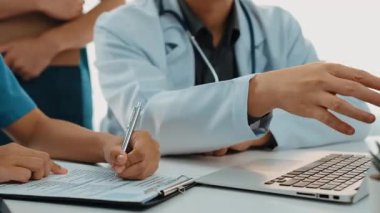 Hasta için hastane masasında çalışan ve tıbbi tedavi planlayanlardan oluşan profesyonel bir ekip. Takım çalışması başarılı hastalıklara ve hastalıklara yol açar. Ağır çekim. Katı.