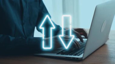 Parlak bir ofiste dizüstü bilgisayarla çalışan bir kişi, dijital dönüşüm kavramını kalite ve maliyet ölçümlerinin görsel göstergeleriyle göstererek, iş verimliliğine odaklanıyor. Dörtgen