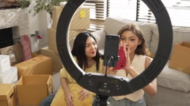 Oturma odasında canlı yayında ürün gösterilirken birkaç etkili kişi yayında. Evde ürün satarken blogger kaydeden çekici bir çift. Çevrimiçi pazarlama konsepti. Myrmidon.