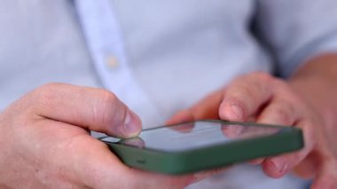 Orta yaşlı bir adam oturma odasındaki koltukta oturur telefon arama verilerini kullanır çocukları iyi bir yetişkin baba ya da eğlence olarak yetiştirir. İşadamı teknolojiyi kolaylık için kullanır. Uyumsuzluk.