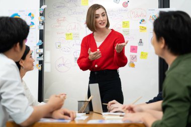 Profesyonel çekici kadın lider, modern iş toplantı odasında beyin fırtınası zihin haritalama istatistikleri ve renkli yapışkan notlar kullanarak yaratıcı pazarlama planını sunuyor. Tertemiz..