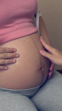 Mutlu hamile kadın, jinekolog doktoru hastanede ya da klinikte hamilelik danışmanlığı için ziyaret ediyor. Doktor, bebek ve anne sağlığı kontrolü için hamile karnı muayene ediyor. Jinekoloji konsepti.