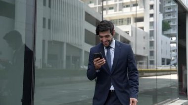 Cam duvarda yürürken neşeyle dans eden yetenekli bir iş adamı. Proje müdürü iyi haberler aldı, terfi aldı, başarılı bir iş buldu, aynı zamanda coşkuyu dile getirdi. Sevinçli..