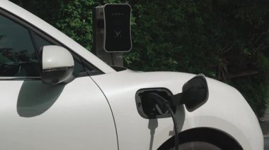 Elektrikli araba parkı ve şarj istasyonunun yanında şarj edilen enerji konseptinin sürdürülebilirliği. Çevresel koruma için yenilenebilir enerji tarafından kullanılan elektrikli araç.