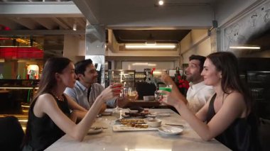 Grup arkadaşı ya da çift masada kokteyl içerken garson da lüks bir restoranda özel ızgara et menüsü sunuyor. Vinosity.