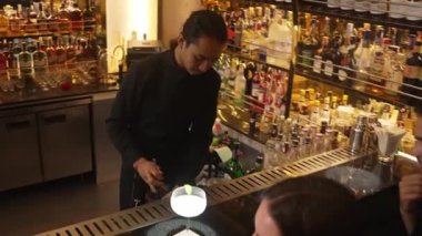 Güzel arkadaşlar lüks bir barda Paloma ve Margarita ile konuşup içerken barmen de güzel bir çiftle parti havasında kokteyl hazırlıyor. Vinosity.