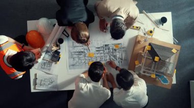 Becerikli mühendis ekibinin ev inşaatından bahsedişinin en alt görüntüsü. Mimar ya da tasarımcı grubunun planlar hakkında beyin fırtınası yapmak için tartışan ve yazan hava görüşü. Hizalama.