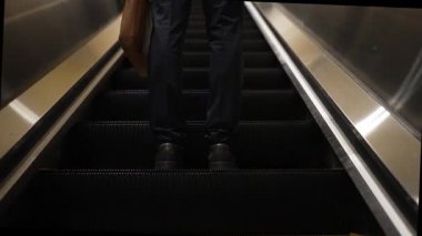 Yürüyen merdivenlerde duran zeki profesyonel iş adamının bacağı. Yetenekli proje yöneticisi terfi alıyor, yeteneğini arttırıyor, yükseltiyor, yeni bir pozisyon alıyor. Merkez. Bacağa odaklan. Sevinçli..