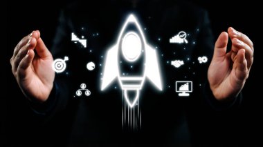 Profesyonel bir işadamı, başarı ve stratejiyi temsil eden çeşitli dijital simgelerle çevrili, büyüme ve yeniliği simgeleyen çarpıcı bir roket konsepti sunar. Dörtgen