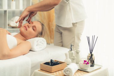 Kafkasyalı kadın stres önleyici kafa masajından ve lüks tatil beldesi ya da otel spa salonundaki modern ışık ortamında yüz güzelliği eğlencelerini şımartmaktan hoşlanıyor. Sessiz.