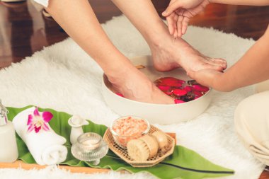 Kadınlar lüks spa salonlarında keyifli ayak masajlarına devam ederken, masör de hafif gün ışığı atmosferinde refleksoloji terapisi veya otel ayak spa 'sında. Sessiz.