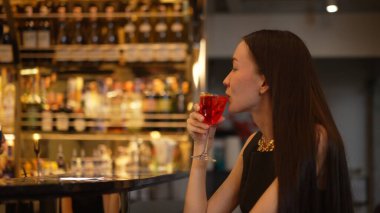 Cosmopolitan kırmızı kokteylinde tek başına güzel bir şekilde oturup arkadaşlarınızı ya da Bokeh 'te bir çifti beklemek cuma gecesi barda ve restoranda lüks bir içki tezgahı yakmak. Vinosity.