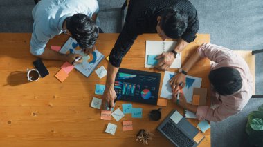 Yönetici, toplantı odasındaki meslektaşlarına mali grafiği açıklar. Farklı pazarlama ekibinin tabletle masada otururken fikir ve planlama stratejisini en üst düzeyde paylaşması. Cemaat.