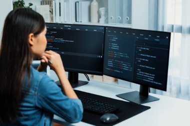 Genç Asyalı bilişim geliştiricisi güzel poz için online bilgi topluyor. Kodlama programı verileriyle birlikte kotlu tişört giyiyor. Güvenlik analizi ile çevrili iki ekran. Taktik.