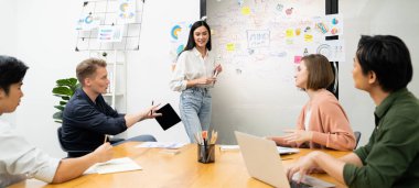 Genç ve güzel lider pazarlama stratejisini sunarken, uzman yatırımcı ve proje yöneticisi de yeni başlayan iş toplantısında iş performansını analiz etmeye çalışıyor. Çok ırklı bir grup. Tertemiz..