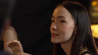 Güzel giyinen bir kadının portresi lüks bir tezgah içecek barında arkadaşıyla sohbet ediyor. Gece kulübünde sosyetik etkileşim sahnesinin özünü yakalıyorum. Vinosity.